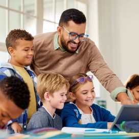 Teacher helping a small group of students learn together